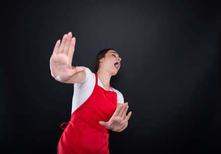 Scared female seller doing rejection gesture with hands feeling tensedの写真素材
