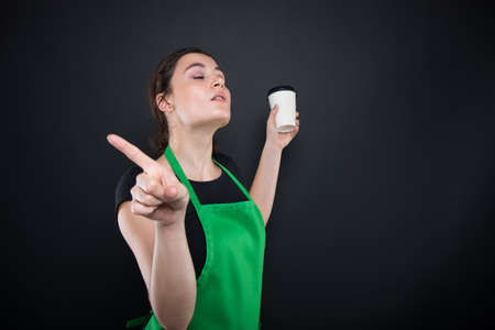 Young girl employee refusing to give you some coffee isolated on black backgroundの写真素材