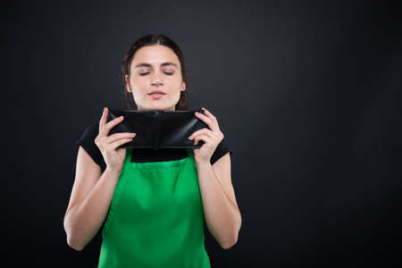 Beautiful female enjoying the smell of money after payday on dark background