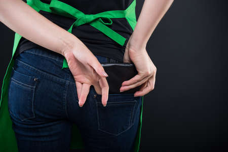 Back view of woman hand taking wallet from his own pocket in close-up viewの写真素材