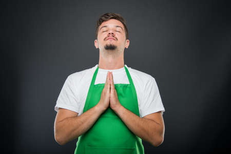 Portrait supermarket employer standing in prayer position like hoping concept on black backgroundの写真素材