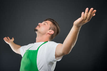 Portrait supermarket employer posing like a winner with hands wide open on black backgroundの写真素材