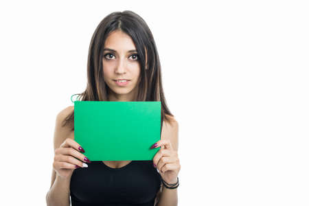 Portrait of fit girl holding green cardboard isolated on white background with copyspace advertising areaの写真素材