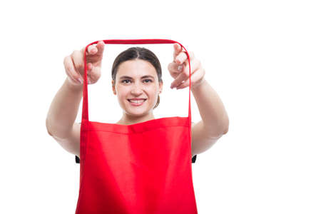 Cheerful female seller putting her apron on getting ready for work on white backgroundの写真素材