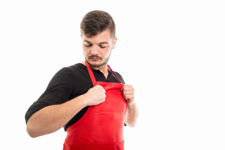 Male supermarket employer holding arranging his apron isolated on white background with copyspace...