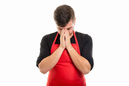 Supermarket employer standing with palm together and eyes down isolated on white background