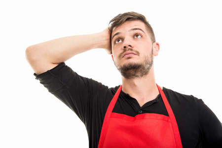 Male supermarket employer holding head like being worried isolated on white backgroundの写真素材