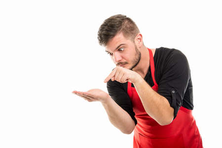 Supermarket employer pointing something in his palm isolated on white background with advertising areaの写真素材