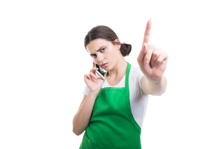 Busy store employee talking with a customer on the phone and doing a hold on gestureの写真素材