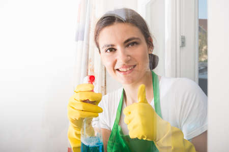 Housekeeping woman ready  for house cleaning smiling and rising thumb up