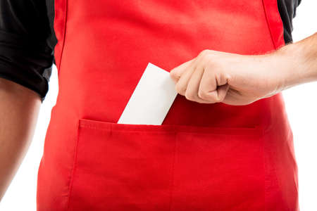 Close-up of supermarket employer putting business card in pocket isolated on white backgroundの写真素材