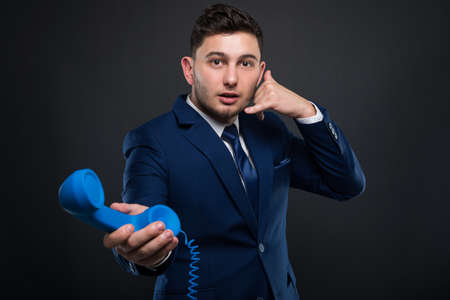 Successful director gesturing a call sign and holding a phone receiverの写真素材