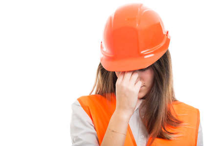 Engineer girl with hardhat got headache and feeling very tired on white backgroundの写真素材