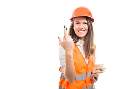 Pretty girl constructor wishing good luck with fingers crossed and smiling on white background with text spaceの写真素材