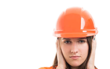 Closeup of woman builder in the hear no evil pose covering her ears on white background with text spaceの写真素材
