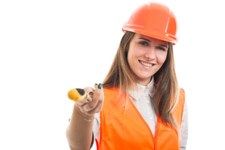 Cheerful pretty female engineer offering a screw to fix something brokenの写真素材