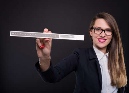 Young female entrepreneur showing measurement ruler and smiling at the cameraの写真素材