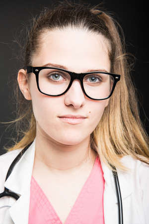 Close-up of attractive female doctor  wearing glasses on black backgroundの写真素材