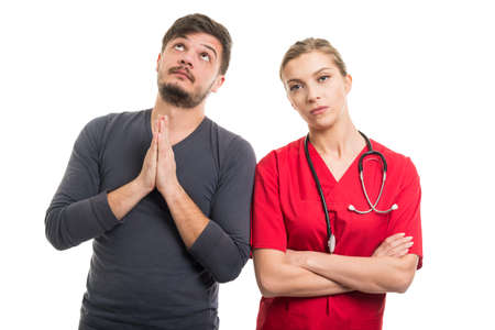 Male patient praying next to lady doctor isolated on white background
