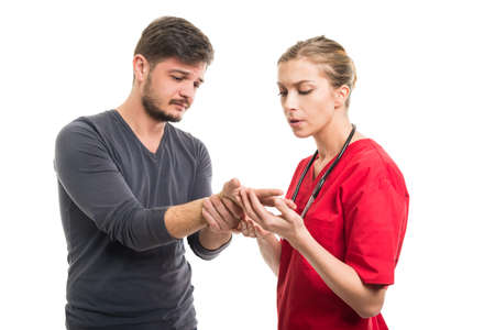 Male patient showing wrist problem to lady doctor isolated on white backgroundの写真素材