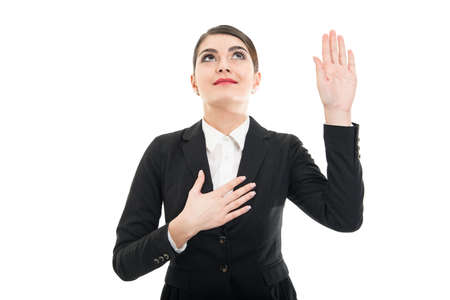 Portrait of beautiful female flight attendant taking oath looking up isolated on white backgroundの写真素材
