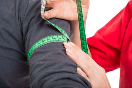 Close-up of male patient being measured by female doctor isolated on white backgroundの写真素材