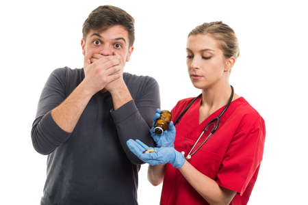 Male patient covering mouth for taking female doctor pills isolated on white background