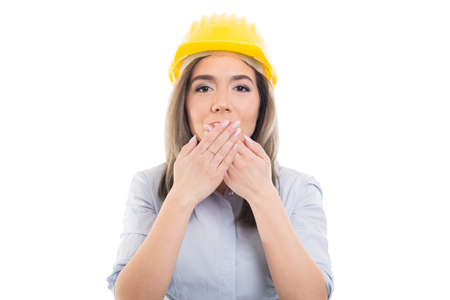 Portrait of female constructor covering her mouth like not speaking on white backgroundの写真素材