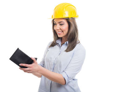Portrait of female constructor looking in her wallet and smiling on white background with copypsace advertising areaの写真素材