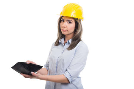 Sad female constructor looking showing her empty wallet on white background with copypsace advertising areaの写真素材