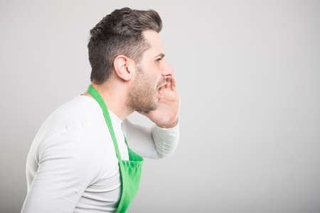 Side view of supermarket employer screaming out loud on white background with copyspace advertising areaの写真素材