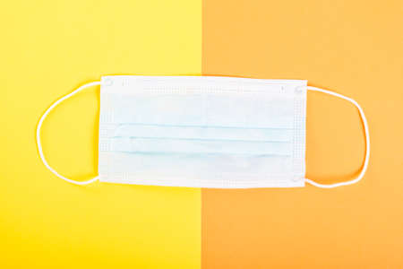 One face sterile mask on yellow and orange backgroundの写真素材