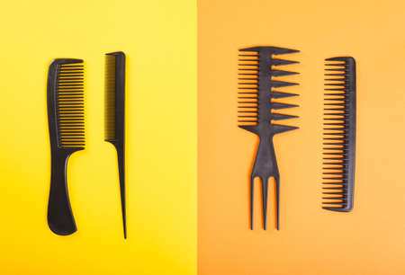 Four black combs on yellow and orange backgroundの写真素材