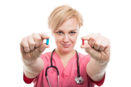 Selective focus of female nurse wearing pink scrubs holding pills isolated on white background with copyspace advertising areaの写真素材
