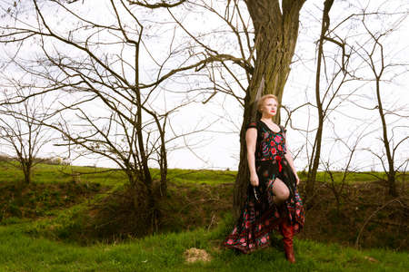 Portrait of cool fashionable woman wearing maxi dress  in the sun outside on countryside background with copypsace advertising areaの写真素材