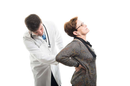 Male doctor checking female senior patient back isolated on white backgroundの写真素材