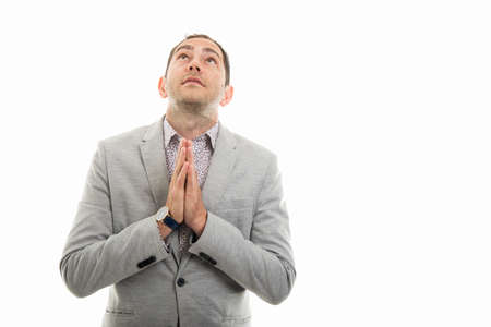 Portrait of business man showing praying gesture isolated on white background with copyspace advertising areaの写真素材