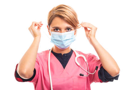 Portrait of female vet wearing pink scrub putting medicine mask on isolated on white background with copyspace advertising areaの写真素材