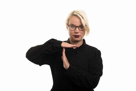 Portrait of young blonde female teacher wearing glasses showing time out gesture isolated on white...