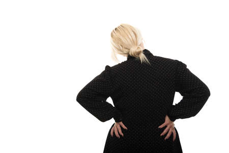 Back view of young blonde female teacher wearing glasses showing back pain gesture isolated on white...