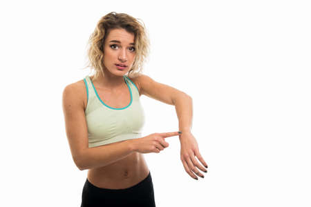 Portrait of beautiful young fit girl showing late gesture isolated on white background with copy...