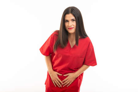 Portrait of nurse wearing scrubs making menstrual pain gesture isolated on white background with...