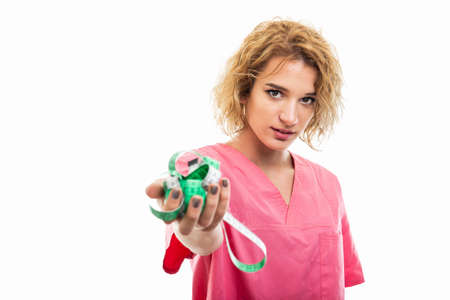 Selective focus of nurse wearing pink scrub holding measure tape isolated on white background with...