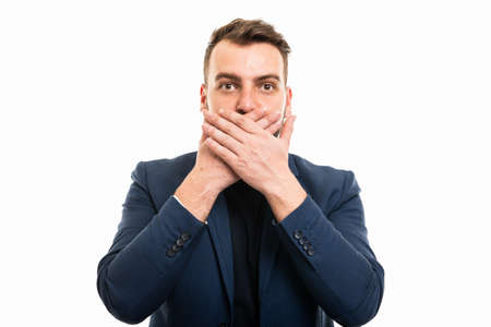 Business man wearing smart casual clothes covering mouth like mute gesture isolated on white...