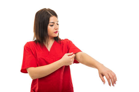 Portrait of beautiful doctor wearing scrubs arranging sleeve isolated on white background with copy space advertising areaの写真素材