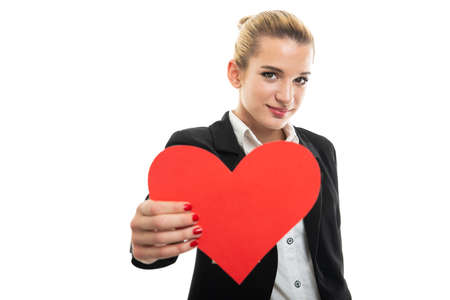Portrait of beautiful young female assistant manager handing red heart isolated on white background with copy space advertising areaの写真素材