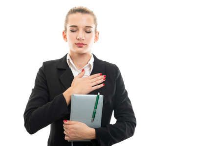 Young female assistant manager holding agenda making oath gesture isolated on white background with copy space advertising areaの写真素材