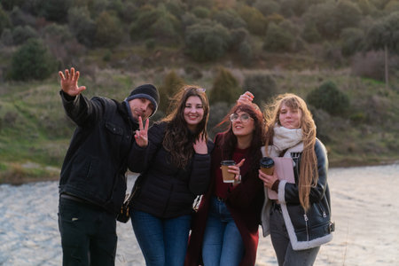 University students enjoying coffee break by river in nature