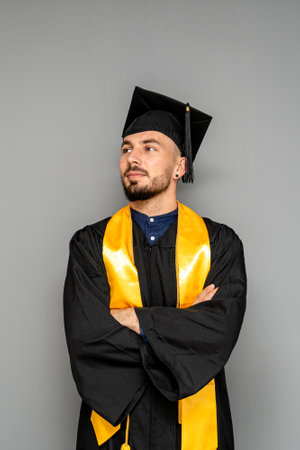 Confident graduate engineer crossing arms and looking away on graduation day