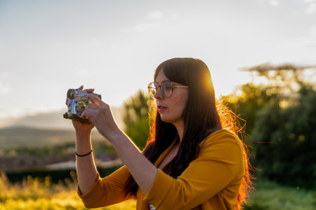 Videographer recording at sunset in rural landscapeの写真素材